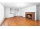 Spacious living room featuring hardwood floors, a brick fireplace, and built in shelves at 1702 Pinecrest St, Burlington, NC 27215