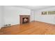 Inviting living room showcasing hardwood floors and a brick fireplace at 1702 Pinecrest St, Burlington, NC 27215