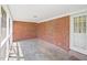 Enclosed porch featuring brick walls, white ceiling, and concrete floors, perfect for relaxation at 1702 Pinecrest St, Burlington, NC 27215