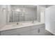 Elegant bathroom featuring double sinks, a large mirror, and a tiled shower, offering spa-like comfort at 195 Babbling Creek Dr, Youngsville, NC 27596