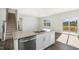 Modern kitchen island with granite countertops and stainless steel appliances, next to stairs and sliding door at 195 Babbling Creek Dr, Youngsville, NC 27596