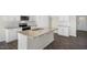 Modern kitchen with granite island, stainless appliances, and white cabinets, perfect for cooking and entertaining at 195 Babbling Creek Dr, Youngsville, NC 27596