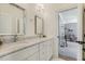 Bright bathroom with double sinks, marble countertop and flooring, leading to a bedroom with a cozy chair at 201 S Ennis St, Fuquay Varina, NC 27526
