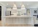 Stylish kitchen featuring a large island with seating, modern lighting, and white cabinetry at 201 S Ennis St, Fuquay Varina, NC 27526