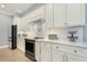 Gourmet kitchen featuring white cabinets, granite countertops, and modern appliances at 201 S Ennis St, Fuquay Varina, NC 27526