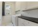 Well-lit laundry room featuring modern appliances, ample cabinet space, and stylish marble tile flooring at 201 S Ennis St, Fuquay Varina, NC 27526