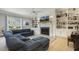 Cozy living room featuring a fireplace flanked by built-in bookcases, a plush sectional, and natural light at 201 S Ennis St, Fuquay Varina, NC 27526