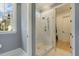 Elegant shower with marble tiling, glass door, and modern fixtures; naturally lit from a window at 201 S Ennis St, Fuquay Varina, NC 27526