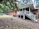 Brick home exterior with screened porch, white railing, and well-maintained lawn at 207 Wood Cir, Chapel Hill, NC 27514