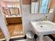 Bright bathroom with a pedestal sink, white tile, and a glimpse into an adjacent bathroom with a classic vanity at 207 Wood Cir, Chapel Hill, NC 27514