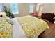 Serene bedroom with hardwood floors, large windows, and a bed adorned with a sunny yellow floral duvet cover at 207 Wood Cir, Chapel Hill, NC 27514