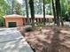 Charming brick ranch with a green garage door, mature trees, and a well-kept lawn at 207 Wood Cir, Chapel Hill, NC 27514