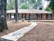 Charming brick home featuring a stone walkway, lush landscaping, and a bright blue front door at 207 Wood Cir, Chapel Hill, NC 27514