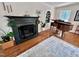 Elegant living room with fireplace, hardwood floors, and a grand piano at 207 Wood Cir, Chapel Hill, NC 27514