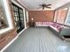 Inviting sunroom with brick walls, ceiling fan, and gray wood floors creating a cozy space for relaxing and entertaining at 207 Wood Cir, Chapel Hill, NC 27514