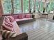 Bright sunroom features a cozy pink couch and lots of natural light from the surrounding trees at 207 Wood Cir, Chapel Hill, NC 27514