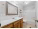 Bathroom with a wooden vanity and a tub with shower at 209 E Church St, Creedmoor, NC 27522