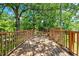 Wooden deck with railings surrounded by green foliage at 209 E Church St, Creedmoor, NC 27522