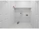 Laundry room with white walls and floors and a storage shelf at 209 E Church St, Creedmoor, NC 27522