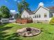 Spacious backyard with a fire pit, wooden deck, and manicured lawn at 229 Hocutt Farm Dr, Clayton, NC 27527