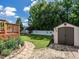 Landscaped backyard showcasing a stone pathway, lush greenery, a storage shed, and a white fence at 229 Hocutt Farm Dr, Clayton, NC 27527