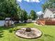Landscaped backyard with fire pit, wooden deck, shed, privacy fence, and mature trees at 229 Hocutt Farm Dr, Clayton, NC 27527