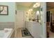 Inviting bathroom with a bathtub, tile floors, and a white vanity, all enhanced by natural light at 229 Hocutt Farm Dr, Clayton, NC 27527