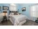 Comfortable bedroom with blue walls, neutral carpeting, a palm frond-inspired bedframe, and plenty of natural light at 229 Hocutt Farm Dr, Clayton, NC 27527