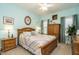 Cozy bedroom featuring a light wood bed frame with a colorful quilt, neutral carpet, and natural light from two windows at 229 Hocutt Farm Dr, Clayton, NC 27527