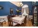 Elegant dining room featuring bold blue walls, hardwood floors, and a decorative window at 229 Hocutt Farm Dr, Clayton, NC 27527