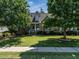 Traditional brick home with manicured lawn, mature trees, and charming front porch at 229 Hocutt Farm Dr, Clayton, NC 27527