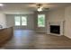 Bright living room featuring hardwood floors, a ceiling fan, and a fireplace with marble surround at 265 Eason Creek Way, Clayton, NC 27527