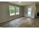 Bright living room featuring hardwood floors, a glass door and multiple windows at 265 Eason Creek Way, Clayton, NC 27527