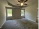 Main bedroom featuring windows, a ceiling fan, and tray ceilings at 265 Eason Creek Way, Clayton, NC 27527