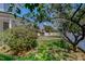 Backyard featuring a white picket fence, trees, bushes, and grass at 29 Oak St, Roxboro, NC 27573