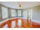 Bright bedroom featuring hardwood floors, neutral walls, three windows, and white trim at 29 Oak St, Roxboro, NC 27573