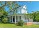 Charming two-story home boasts a wrap-around porch with stately columns and a metal roof at 29 Oak St, Roxboro, NC 27573