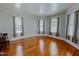 Sun-filled living room featuring hardwood floors and multiple windows with decorative curtains at 29 Oak St, Roxboro, NC 27573