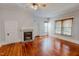 Living room featuring hardwood floors, a ceiling fan, and a fireplace at 29 Oak St, Roxboro, NC 27573