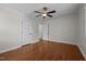 Empty bedroom with neutral paint, wood floors, ceiling fan, and three doors at 301 Williamson St, Burlington, NC 27215