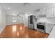 Open concept kitchen features stainless appliances, and white cabinets that flows into the living room at 301 Williamson St, Burlington, NC 27215
