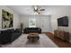 Spacious living room featuring hardwood floors, ceiling fan, large windows, and modern decor at 301 Williamson St, Burlington, NC 27215