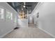 Bright living room with wood-look flooring, gray walls, ceiling fan, and kitchen access at 301 Williamson St, Burlington, NC 27215