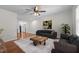 Spacious living room featuring hardwood floors, ceiling fan, large windows, and modern decor at 301 Williamson St, Burlington, NC 27215