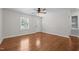 Open living room featuring hardwood floors, ceiling fan, and large windows at 301 Williamson St, Burlington, NC 27215