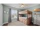 Cozy bedroom with a bunk bed featuring built-in storage and a window with tree-filled views at 302 Slate Dr, Gibsonville, NC 27249