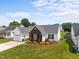 Well-maintained home showcasing brick accents, tidy landscaping, and an attached garage at 302 Slate Dr, Gibsonville, NC 27249