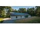 Contemporary home features a sleek metal roof, a glass-walled pool enclosure, and lush green landscaping at 345 Wake County Line Rd, Zebulon, NC 27597