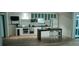 Modern kitchen with white cabinets, stainless steel appliances, island, and hardwood floors provides a bright space at 345 Wake County Line Rd, Zebulon, NC 27597