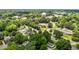 Wide aerial view showcasing a water tower, lush trees, roads, and various homes and businesses at 347 W Trade St, Burlington, NC 27217